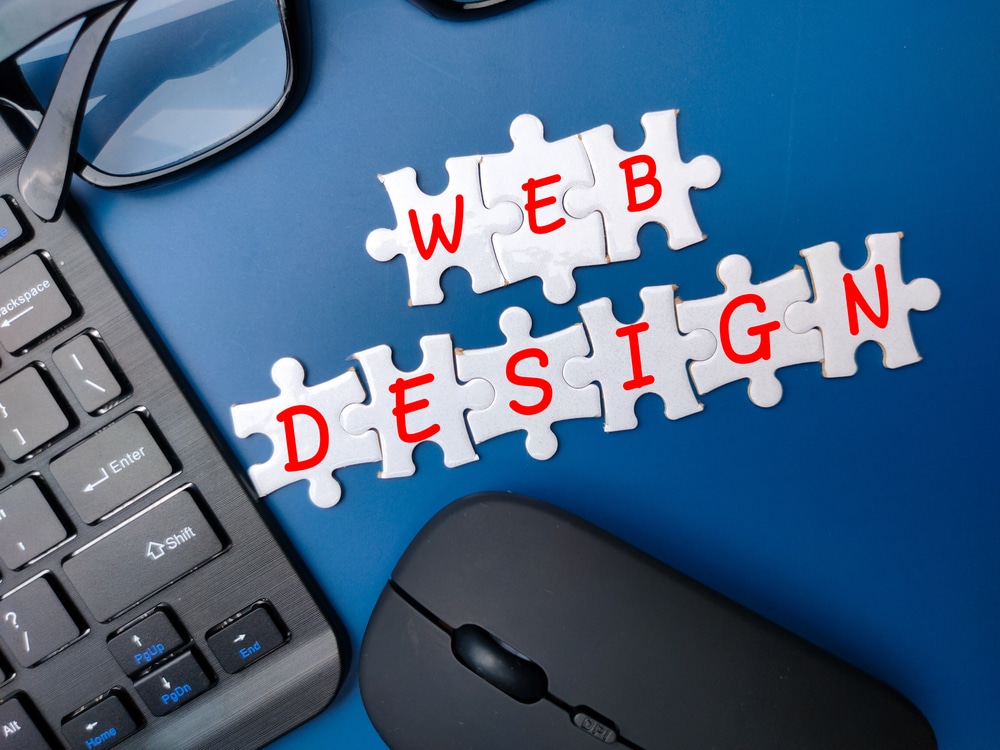 Wireless keyboard and mouse with the word WEB DESIGN on a blue background.