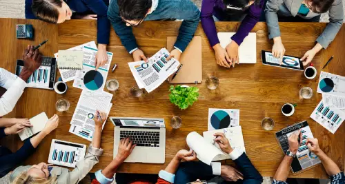 Overhead view of a diverse team collaborating around a wooden table